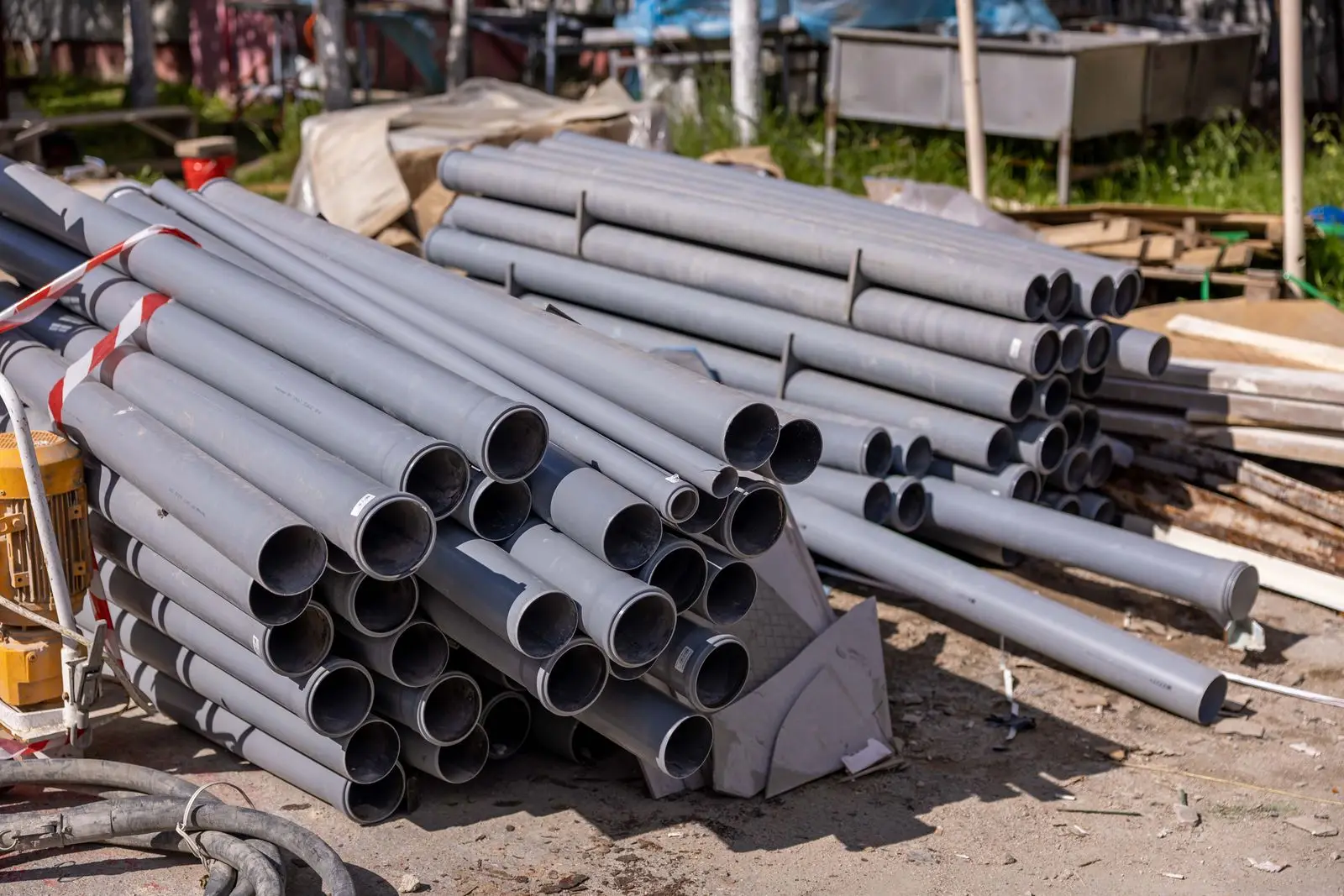 Tubos de PVC gris apilados en una obra